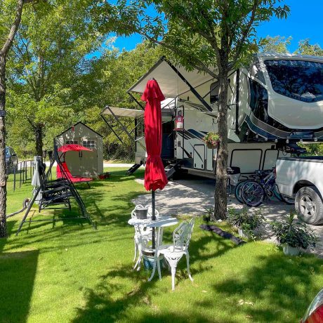 parked rvs in grassy area with trees